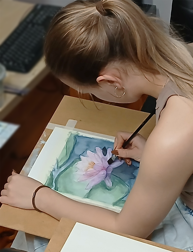 student painting waterlilies with watercolor